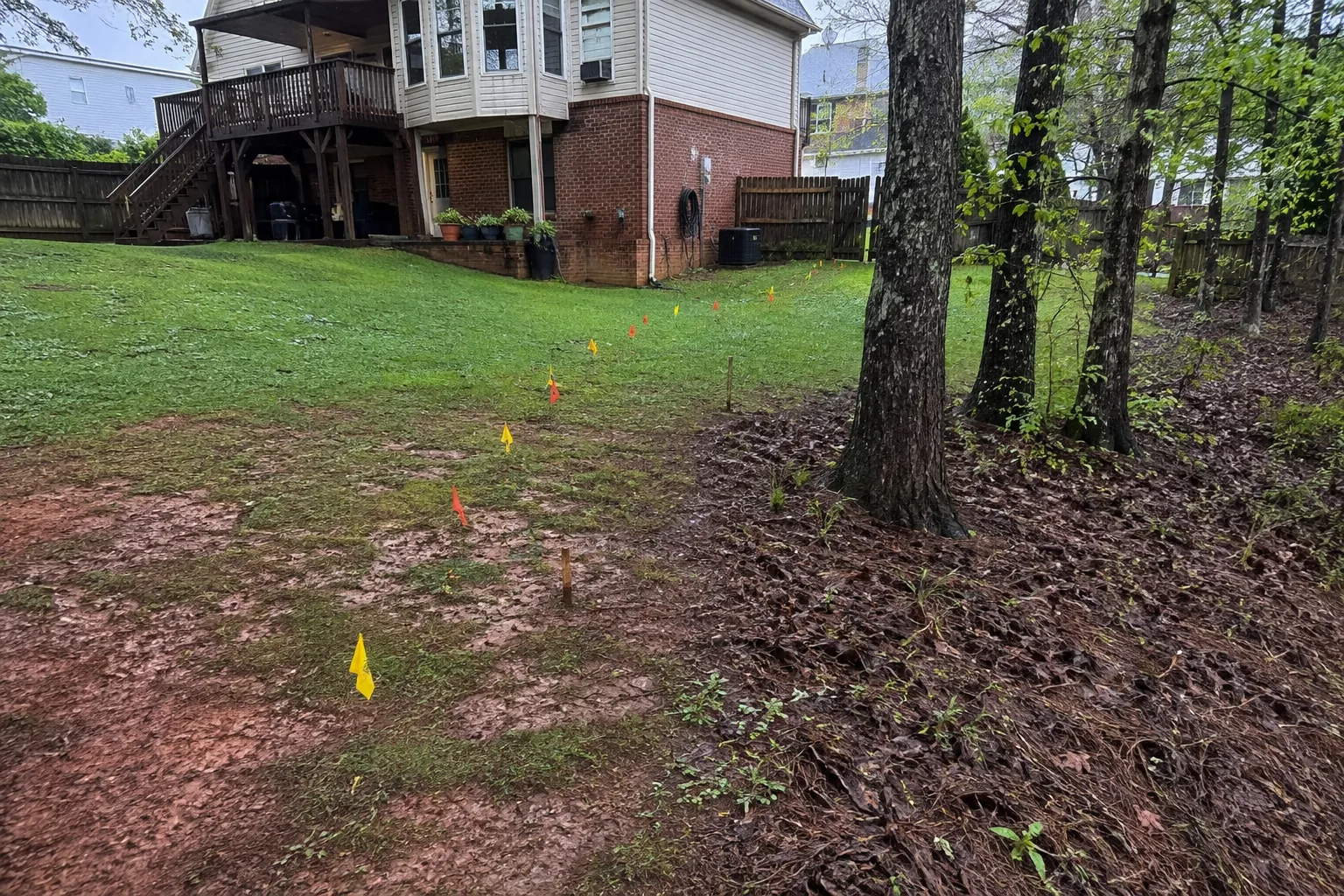 Residential yard drainage route being assessed after rain